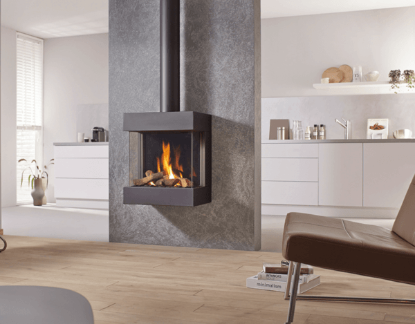 DRU Diablo Next is a classic, 3-sided suspended gas fire pictured here in black. It is mounted directly onto an grey outside facing feature wall, with no chimney breast. The black exposed flue pictured from the top of the fire can be concealed behind a matching flue cover.
