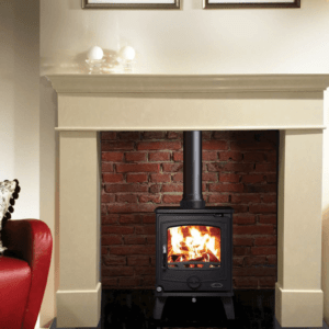 Classic black Cambridge stove with matching black pipework set against a red brick chamber and marble fireplace