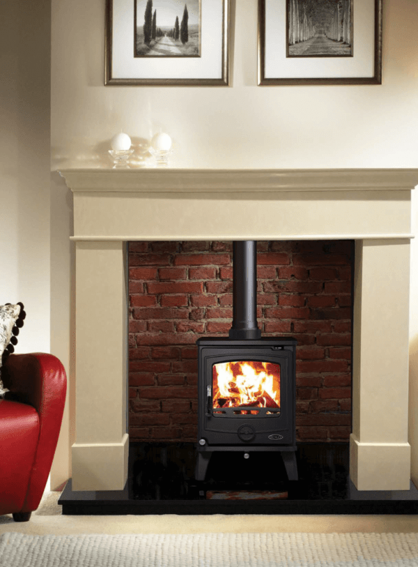 Classic black Cambridge stove with matching black pipework set against a red brick chamber and marble fireplace