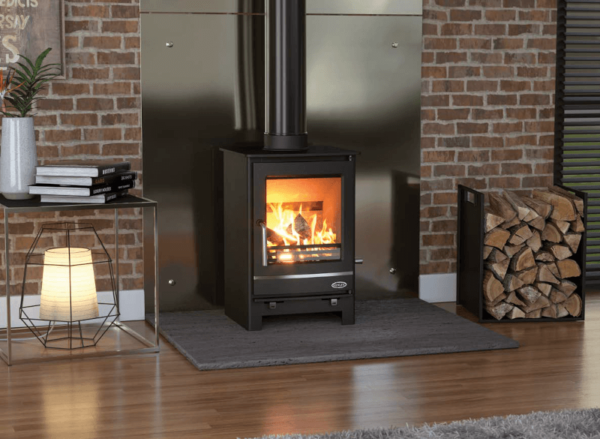 With a sleek and clean design the Henley Hampshire is classic addition to any room, Pictured here in black with matching pipe work and large viewing window and blaxing fire within. The Hampshire is pictured set on a black slate hearth and set against a chrome feature back plate