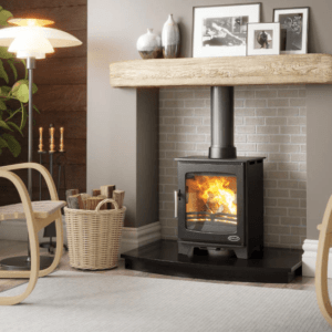 Elegant classic black stove with large viewing window and matching black pipework. Positioned in a cream brick chamber with timber mantle and black granite hearth