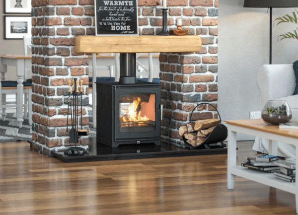 Classic black stove with matching black pipework and large viewing window. This stove is pictured set into a redbrick feature wall with a timber mantle and a black granite hearth