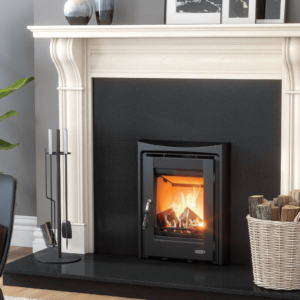 The black Muckross fully cast-iron stove is pictured here set into a black granite insert. It is set upon a black granite hearth and surrounded by a white marble fireplace