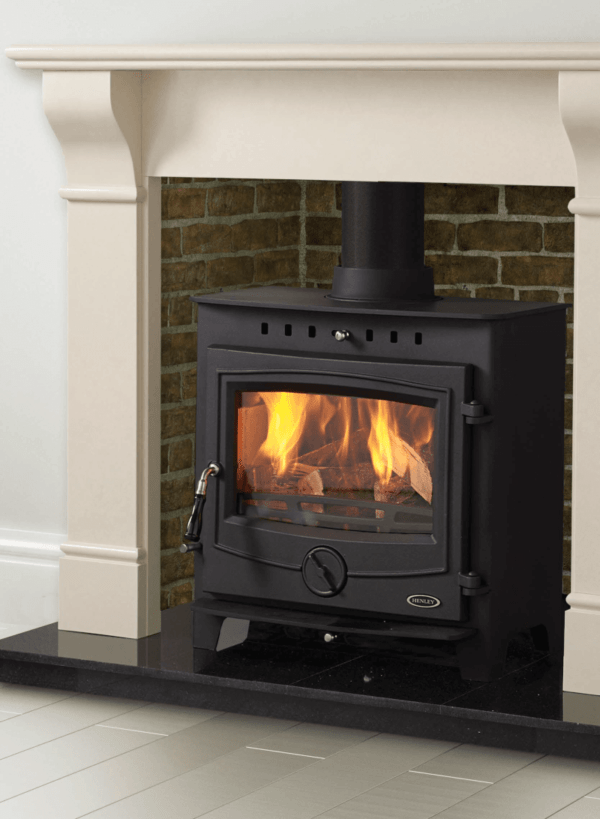 18kW Multi-fuel Insert Achill Boiler Stove in black. Set against a brick chamber in an off white stone surround with a black granite hearth