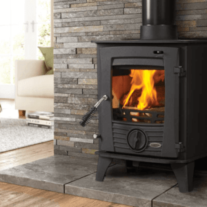 The Druid high grade steel with a heavy cast iron door, pictured in black with a blazing fire behind the viewing window. The Druid Stove from Elegant Fires is pictured here sitting on top of a grey marbled stone hearth with a matching stone cladding feature wall back drop