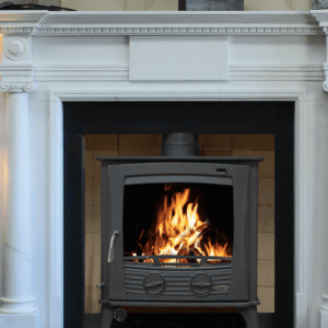 30kW Multi-fuel Insert Boiler Stove in black. Constructed from high grade steel with a heavy cast iron door. Set into a brick chamber with black insert and white marble surround