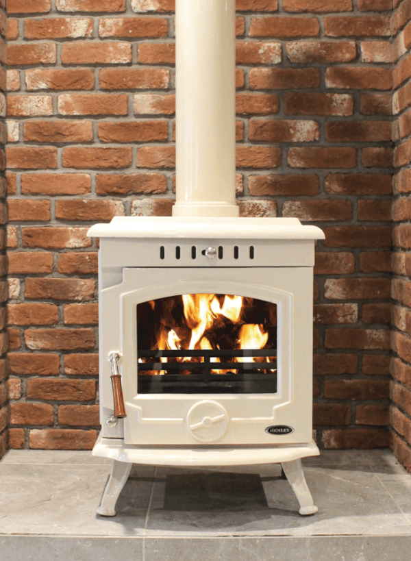 Stunning white enamel stove with timber design handle and blazing fire seen through viewing window. Set against a brick chamber backdrop